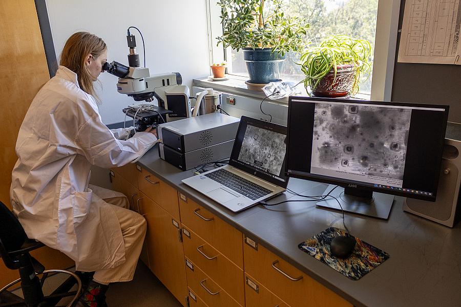 A student using an advanced optical microscope.