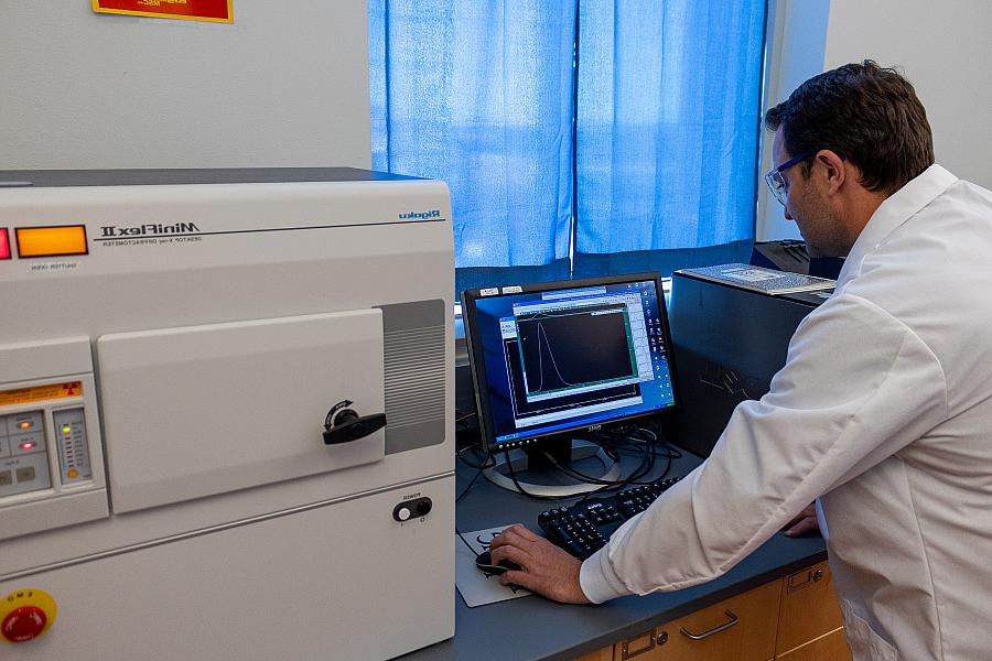 A professor using a X-Ray diffraction instrument.